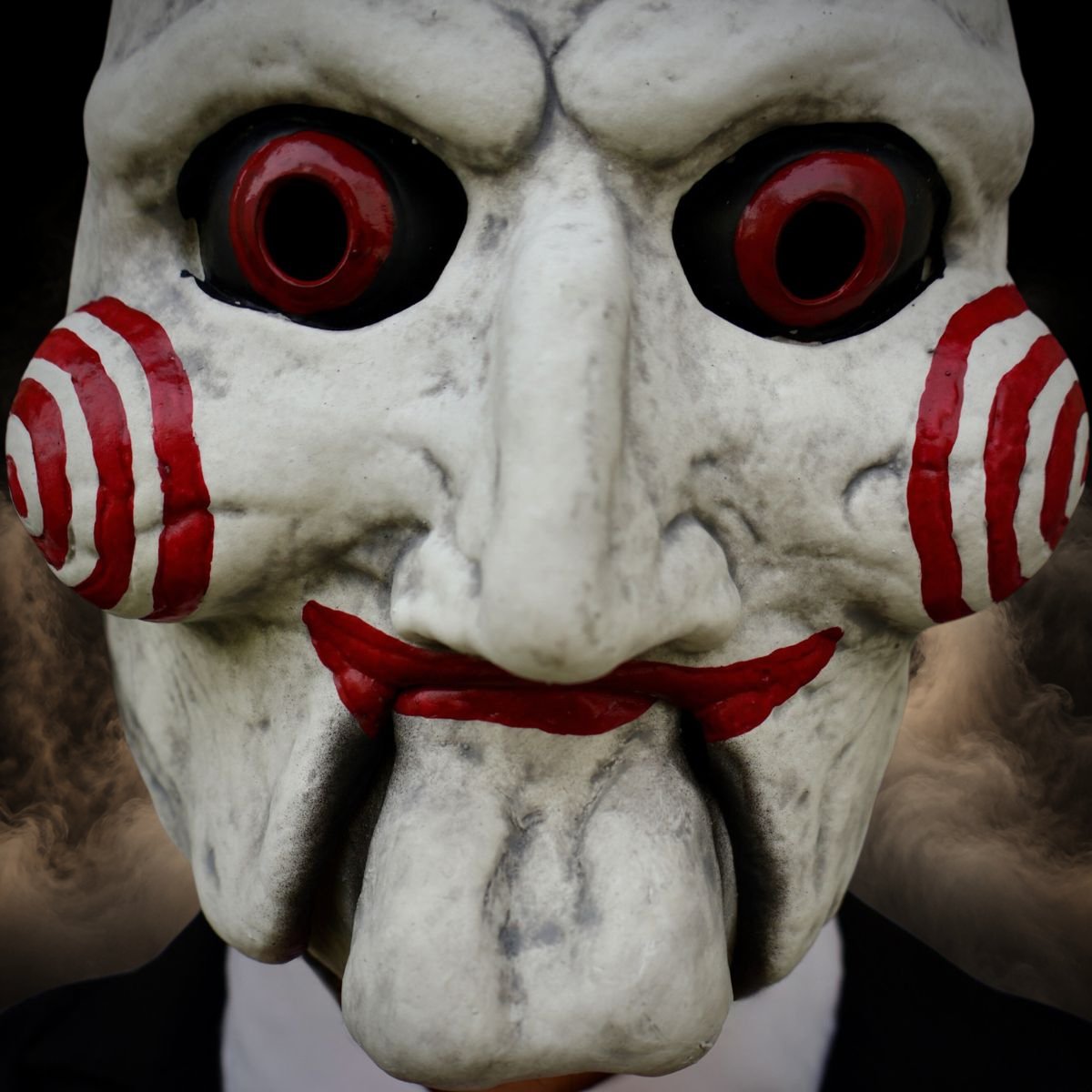 Close up of the red spiral cheeks, red eyes and the hinged jaw on a puppet mask