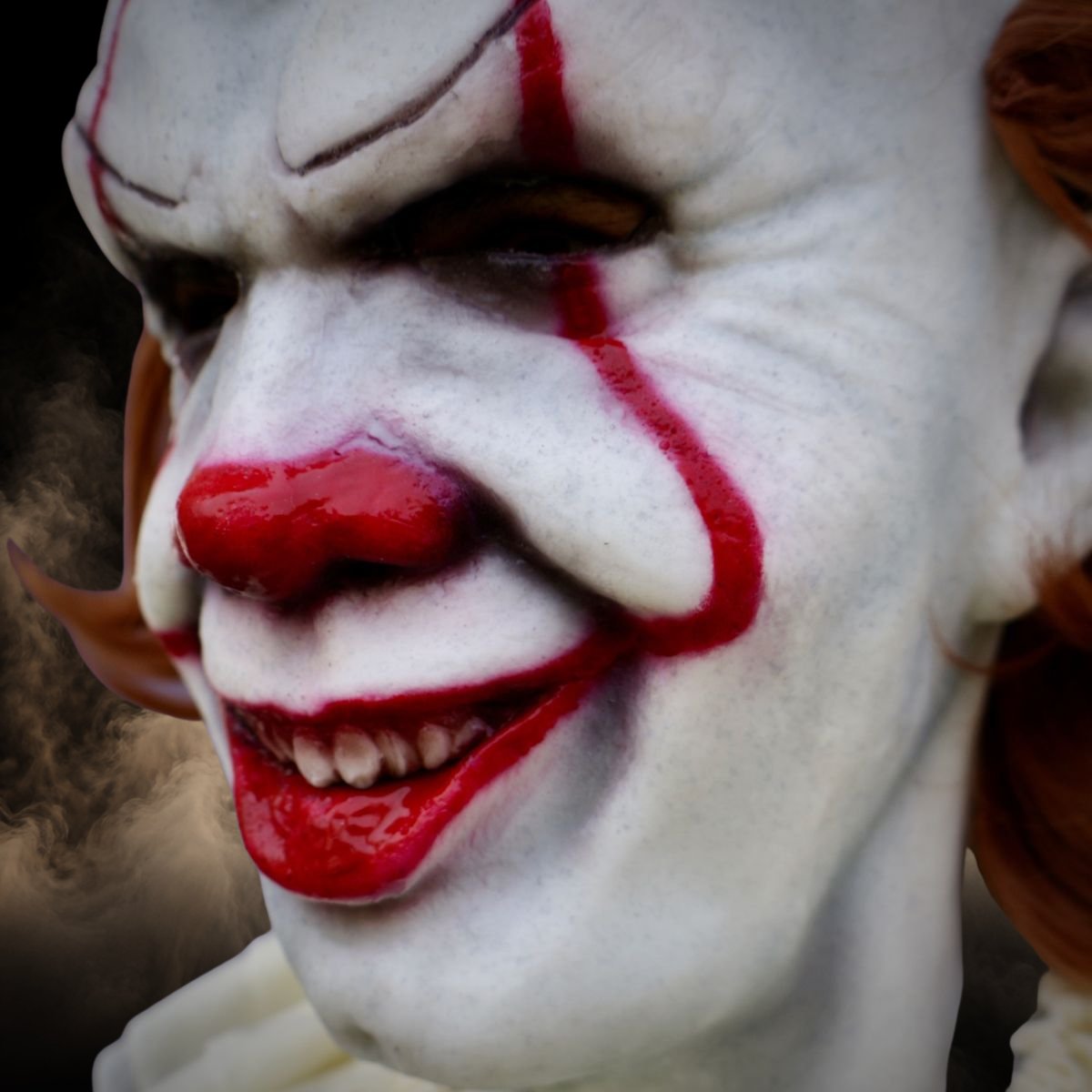 Killer clown halloween mask close up on the painted eyes and red lips